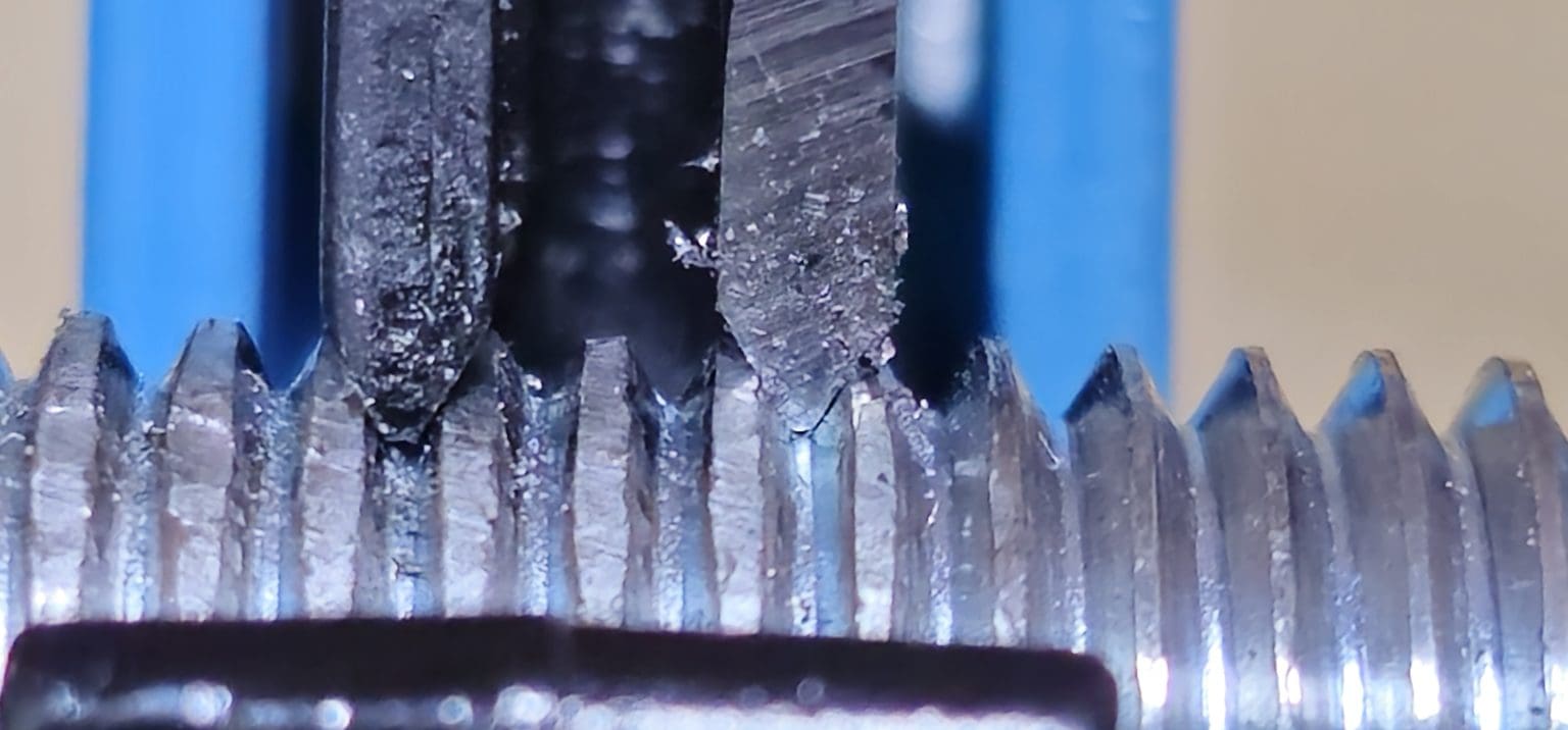 Close-up of a thread after a cutting repair, showing torn flanks