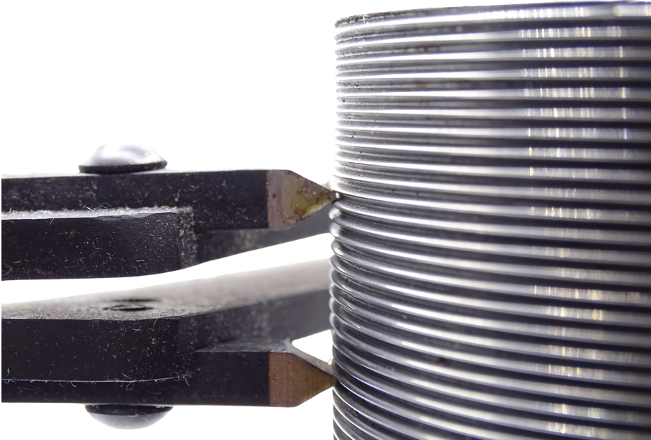 A universal thread-scratcher cutting tool clamped onto a threaded rod